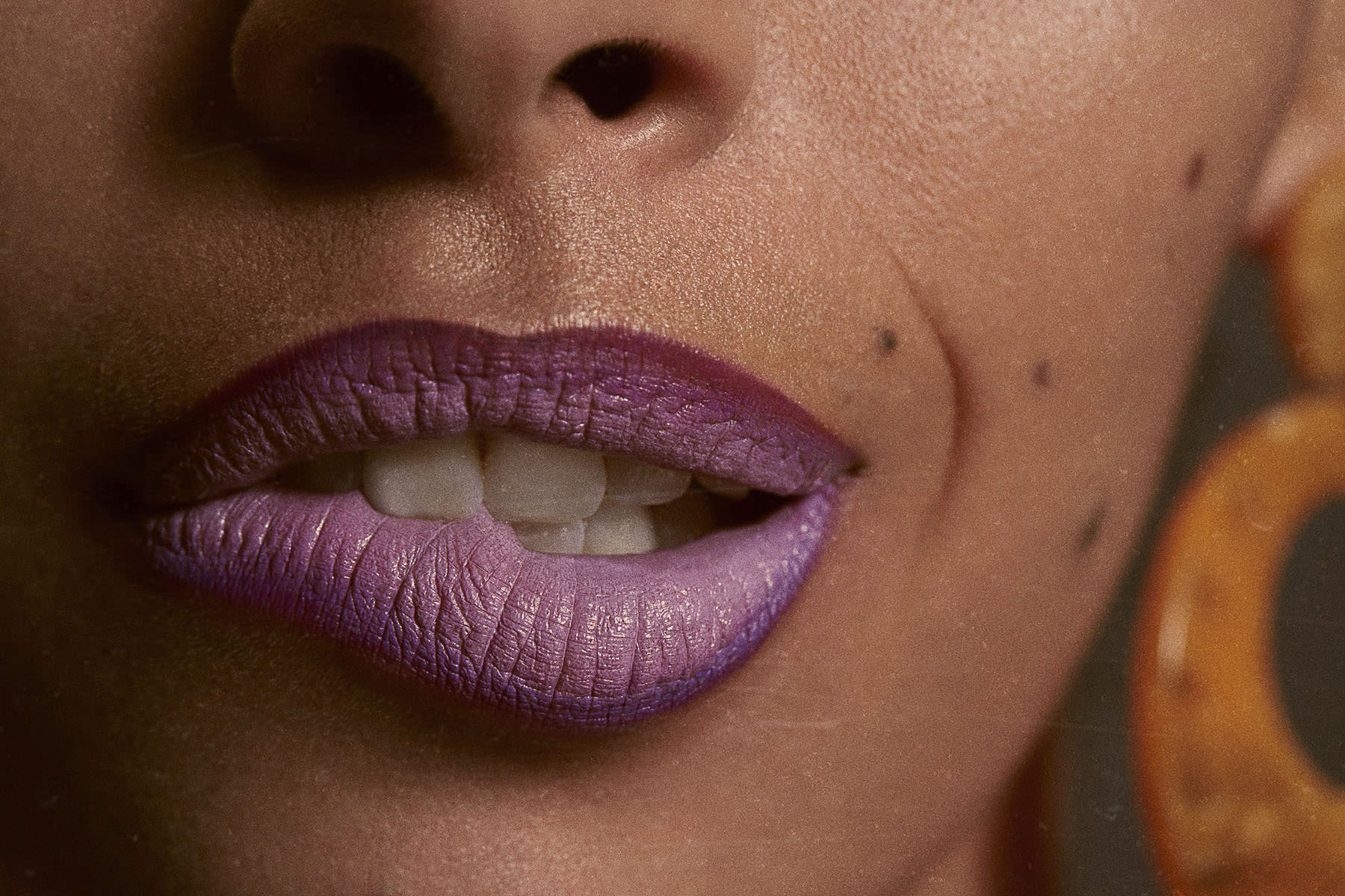 Women with Makeup biting lips wearing purple lipstick 